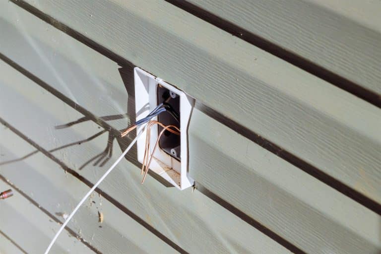 Electrical box with wires coming out of exterior siding before a fixture is mounted