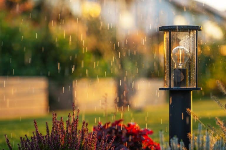 Garden post light standing in a passing rain shower