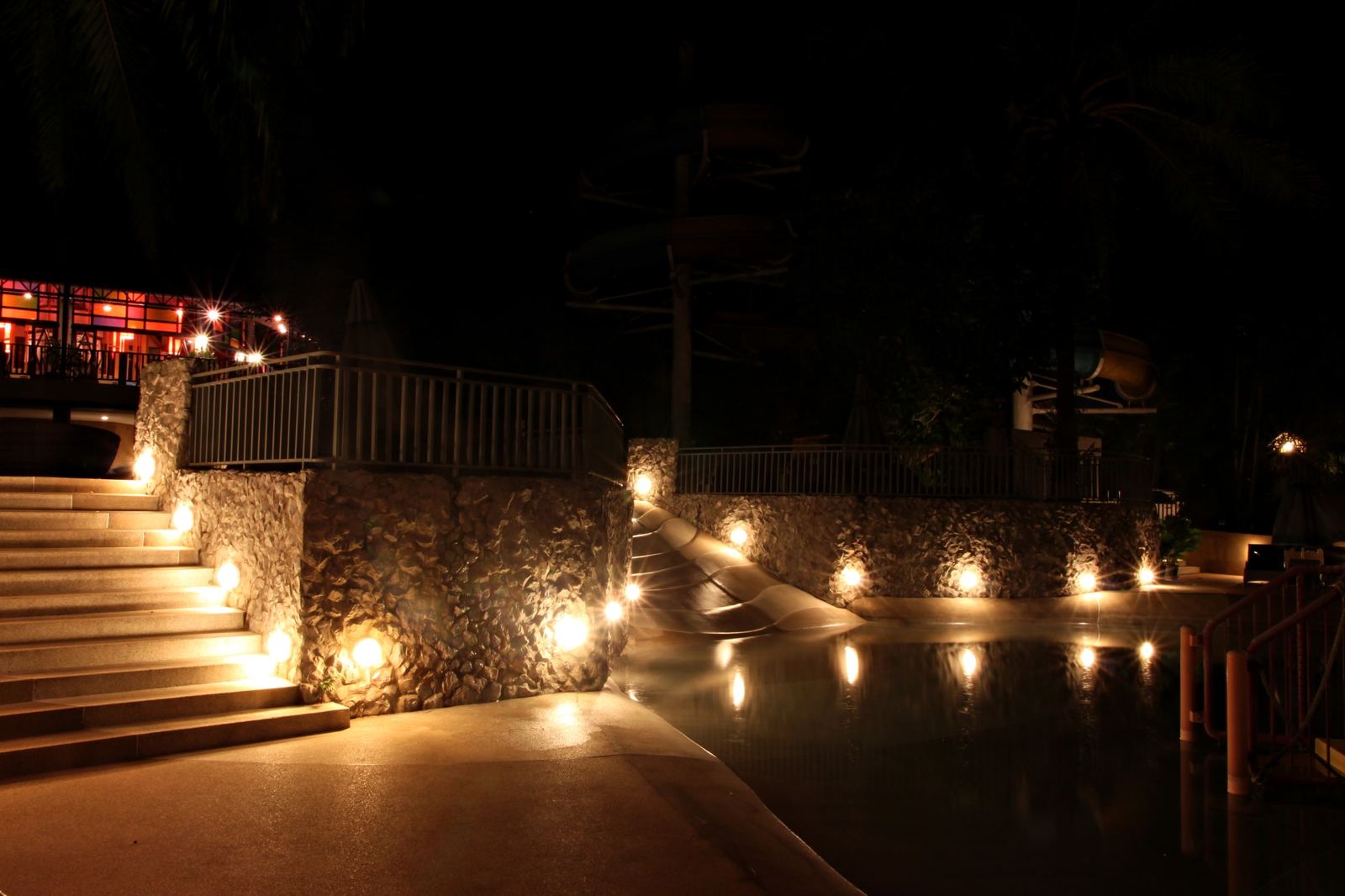 Stone steps and a wall lit by warm accent lights at night