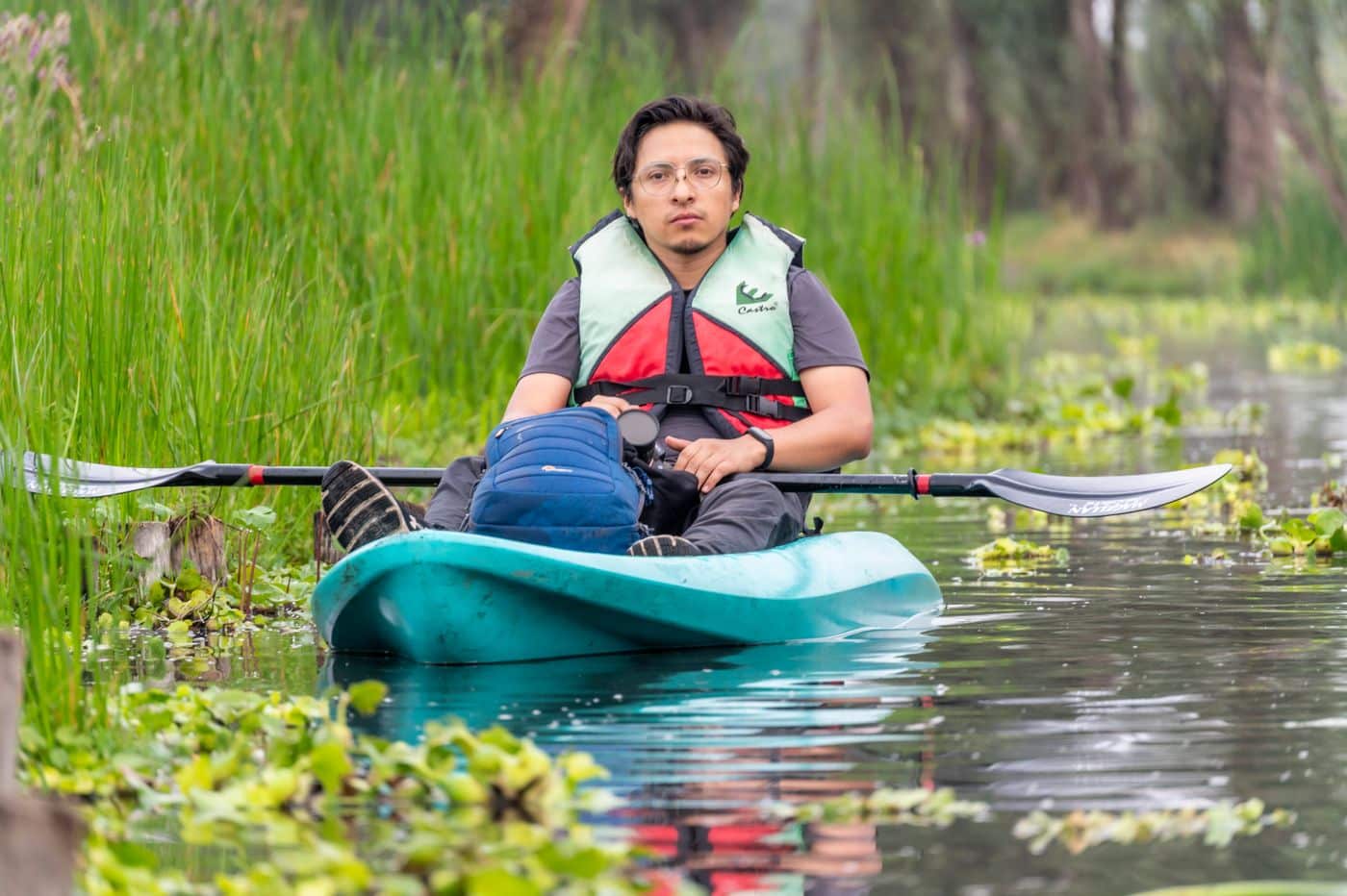 Kayaker paddling through a swamp